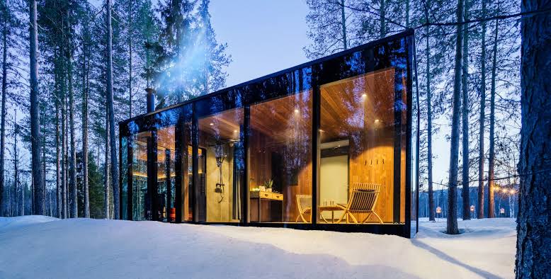 A snow-covered winter lodge under a pale northern sky