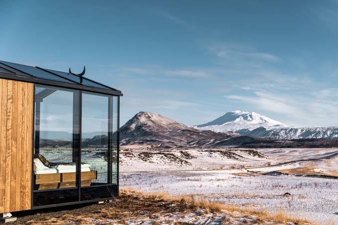 A dark timber house standing alone on open ground in south Iceland