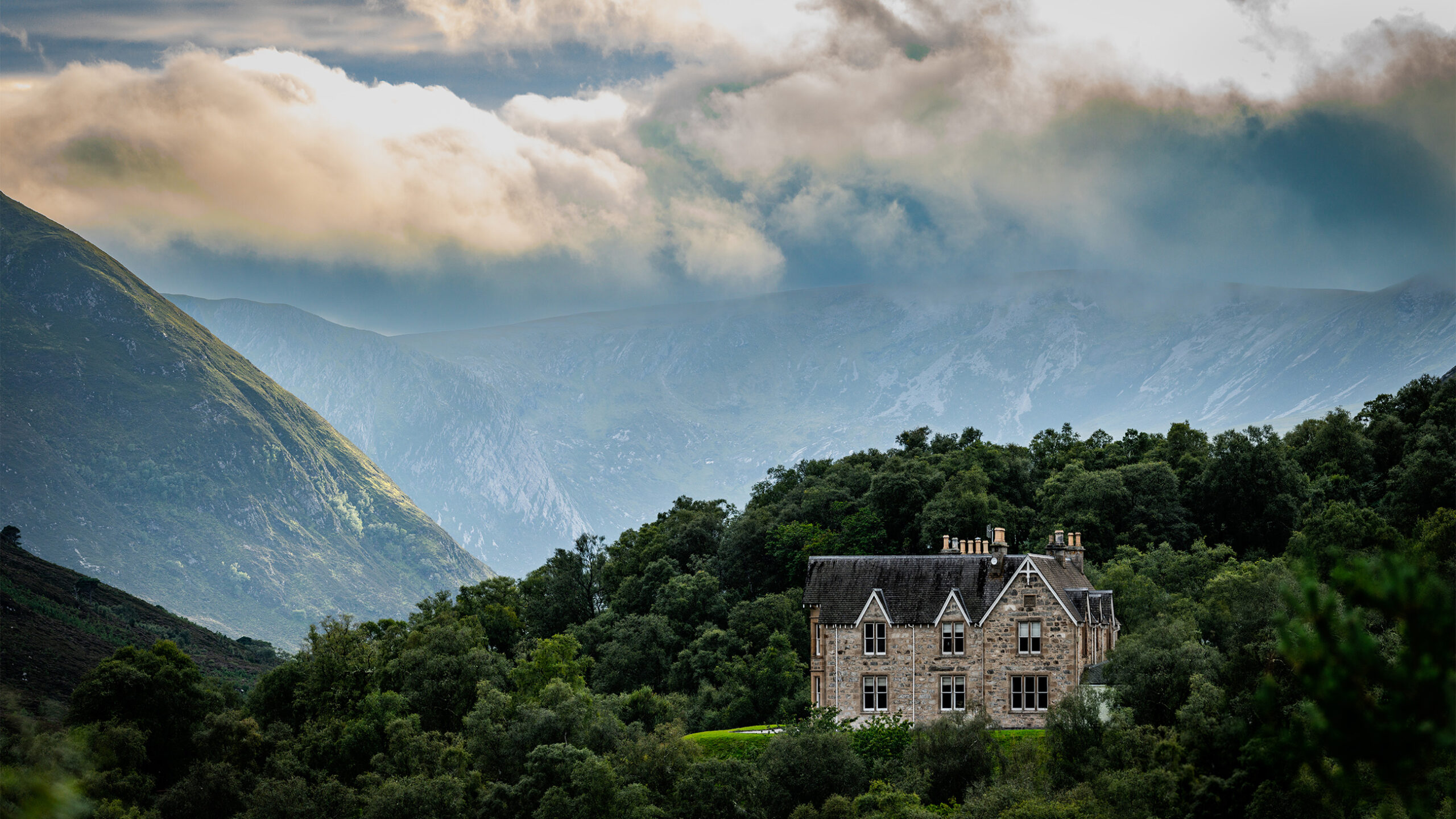 A stone cottage on the Alladale Wilderness Reserve with Highland hills behind it